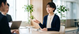 面接で自己紹介をしながら身ぶりを交えて話す若い女性の応募者と面接官